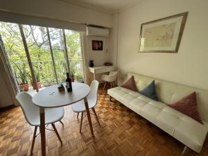 uma sala de estar com um sofá branco e uma mesa em palermo frente al Zoo em Buenos Aires