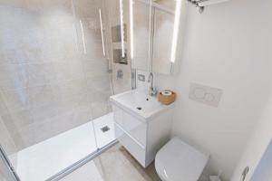 a bathroom with a shower and a toilet and a sink at Lakeview Panorama Penthouse with Washer & Dryer in Lugano