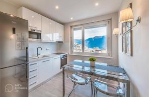 a kitchen with a glass table and a window at Lakeview Panorama Penthouse with Washer & Dryer in Lugano