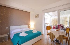 Un dormitorio con una cama y una mesa y sillas. en Stunning Home In Pozzallo With Sauna, en Pozzallo