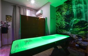 Una sala de estar con un gran acuario con iluminación verde. en Stunning Home In Pozzallo With Sauna, en Pozzallo
