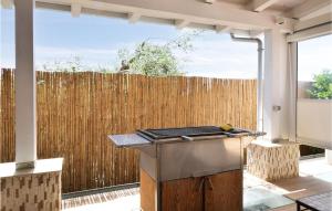 Una cocina en el patio trasero con parrilla y cerca. en Stunning Home In Pozzallo With Sauna, en Pozzallo