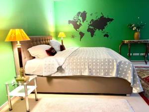 a bedroom with a bed with a green wall at Doppelzimmer Gartenblick Villa Julian in Aurich