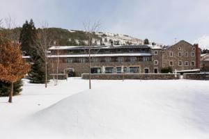 a building in the snow with a pile of snow at Hotel Bernat de So in Llivia
