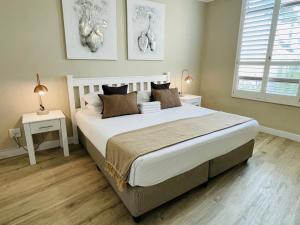 a bedroom with a large bed and two windows at Breakers Resort Apartments in Durban