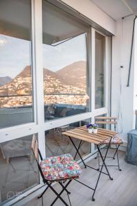 a balcony with a table and chairs and a view at Lakeview Panorama Penthouse with Washer & Dryer in Lugano