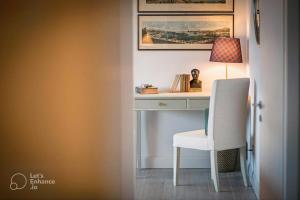 un bureau avec une chaise et une lampe. dans l'établissement Lakeview Panorama Penthouse with Washer & Dryer, à Lugano