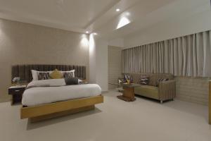 a bedroom with a large bed and a couch at Hotel Ariana Residency in Mumbai