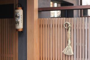 una escoba colgada en una valla de madera en HOTEL和紡 en Nagoya