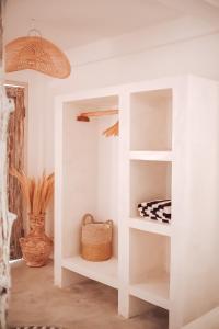 a white book shelf in a room with a basket at VILLA LA ISLA BONITA walking distance to the beach in Gili Air