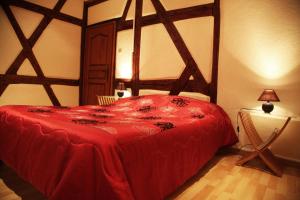 a bedroom with a large bed with a red blanket at La Grenouille in Turckheim
