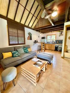 uma sala de estar com um sofá e uma mesa em Fare Auti - halfway beach and mountain on Moorea em Haapiti