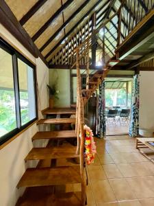 escalera de madera en una habitación con ventanas en Fare Auti - halfway beach and mountain on Moorea en Haapiti