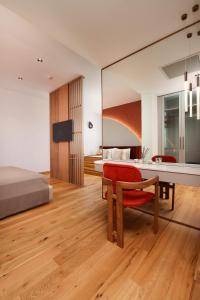 a bedroom with a bed and a desk and a red chair at Genesis Hotel&Spa Alaçatı in Alaçatı
