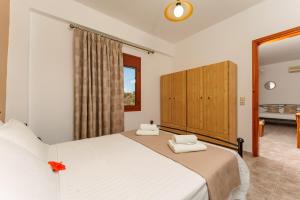 ein Schlafzimmer mit einem Bett mit zwei Handtüchern darauf in der Unterkunft Hara's Apartments in Kastrí