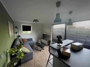 een woonkamer met een bank en een tafel bij Wiedenhuisje in Belt-Schutsloot