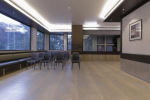a waiting room with chairs and tables and windows at Hotel Ariana Residency in Mumbai