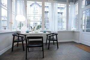 jadalnia ze stołem, krzesłami i oknami w obiekcie Sopot Special Apartments w mieście Sopot