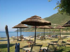 a group of chairs and umbrellas on a beach at Hotel Grand Nefeli in Vasiliki