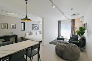 Habitación con cama, mesa y sillas. en Hotel FANDINA TOKYO -ファンディーナ東京-, en Tokio
