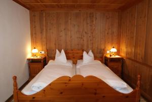 a bedroom with a bed with two lamps on two tables at Haus Landbrugg in Lech am Arlberg