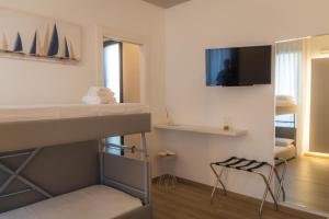 a room with a bunk bed and a tv on the wall at La Casa Di Filò Boutique in Roseto degli Abruzzi
