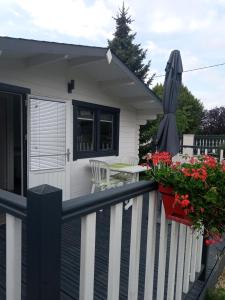 a house with a balcony with a table and an umbrella at Chalet climatisé et chauffé a Faverges de la Tour in Faverges-de-la-Tour