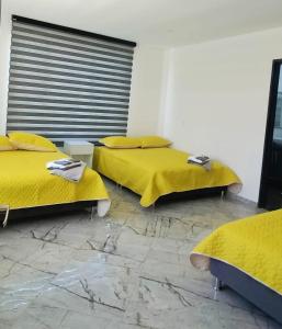 Dos camas en una habitación con mantas amarillas. en Nueva, Moderna casa en Silvania con Jacuzzi, en Silvania