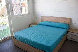 a bedroom with a bed with a blue blanket on it at AURORA BEACH & SUITE in Margherita di Savoia +87 photos