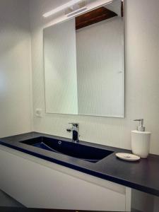 a bathroom with a blue sink and a mirror at Skudehandelen. in Lønstrup