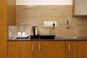 a kitchen counter with a coffee maker and a sink at Moois Residency ,Bangalore in Bangalore