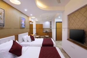 a hotel room with two beds and a flat screen tv at Moois Residency ,Bangalore in Bangalore