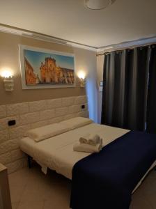 a bedroom with two beds and a painting on the wall at Al Settimo porta marina in Syracuse