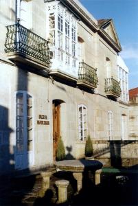 - un grand bâtiment avec une porte bleue et un balcon dans l'établissement Pazo Almuzara, à Boborás