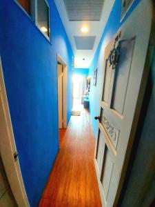 um corredor com paredes azuis e piso de madeira em 韖旅店-民宿編號1158 em Kenting