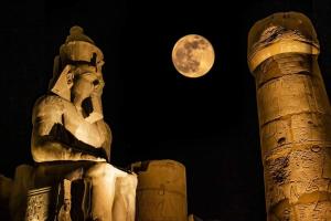 a statue with a moon in the background at Modos place in Luxor