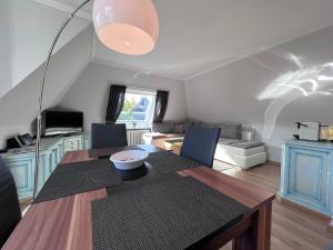 Meer-Lust-Sylt sea cottage في فيسترلاند: غرفة طعام مع طاولة وغرفة معيشة