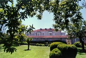 a large green building with a tree in front of it at Pazo Almuzara in Boborás