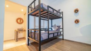 a bedroom with two bunk beds in a room at Aura Dormitory House Ubud in Ubud