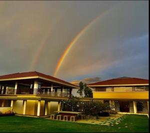 a rainbow in the sky over a house at Nambiar Club Bellezea in Bangalore