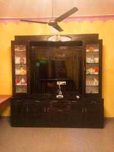 a entertainment center with a television in a room at Sai Homestay in Kanchipuram