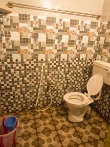 a bathroom with a toilet with a hose at Sai Homestay in Kanchipuram