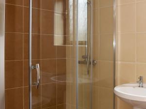 a shower with a glass door next to a sink at Hay Fields, Tilmangate Farm in Ulcombe