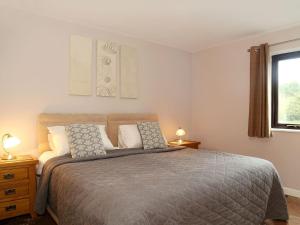 a bedroom with a bed with two lamps and a window at Hay Fields, Tilmangate Farm in Ulcombe