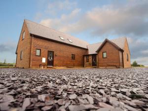 een groot houten huis op een grindweg bij Hay Fields, Tilmangate Farm in Ulcombe