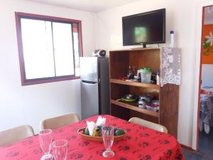 uma sala de jantar com uma mesa e uma televisão em Cabañas y Hostal Vai Hinaaro em Hanga Roa