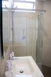een badkamer met een wastafel en een douche bij AURORA BEACH & SUITE in Margherita di Savoia