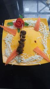 a yellow plate with food on it with carrots and noodles at Bogar Palace Kodaikanal in Kodaikānāl