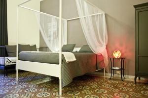 sypialnia z łóżkiem z baldachimem w obiekcie Happy Stay Guesthouse w Rzymie