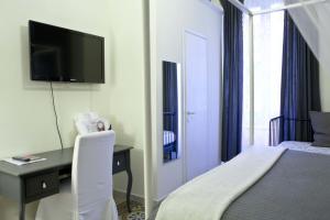 pokój hotelowy z łóżkiem, biurkiem i telewizorem w obiekcie Happy Stay Guesthouse w Rzymie